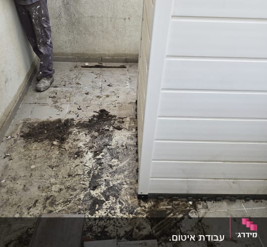 אדם עומד ליד קיר, רצפה מלוכלכת עם אריחים שבורים